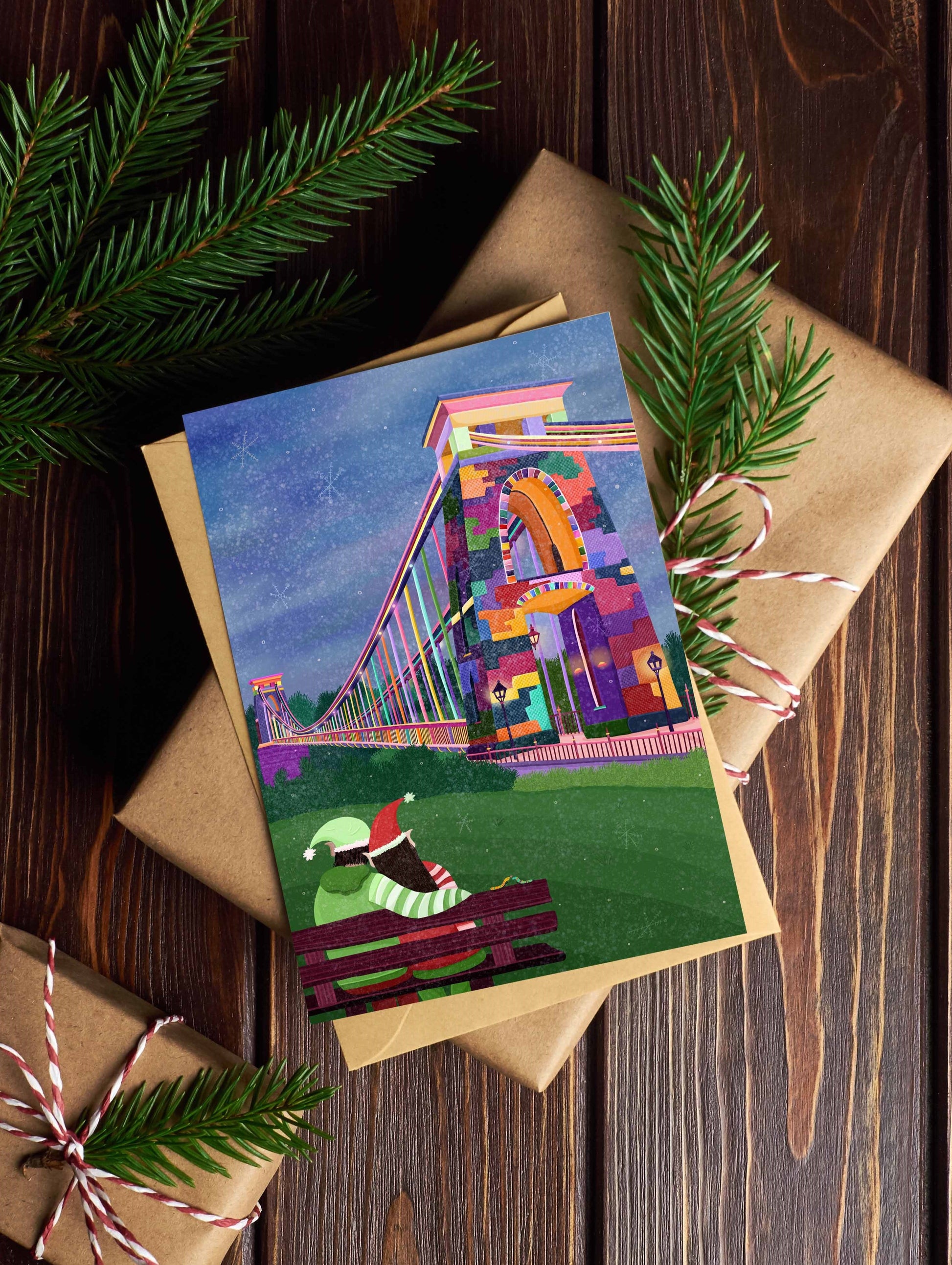 Colorful greeting card with a festive design on a wrapped gift with pine branches.