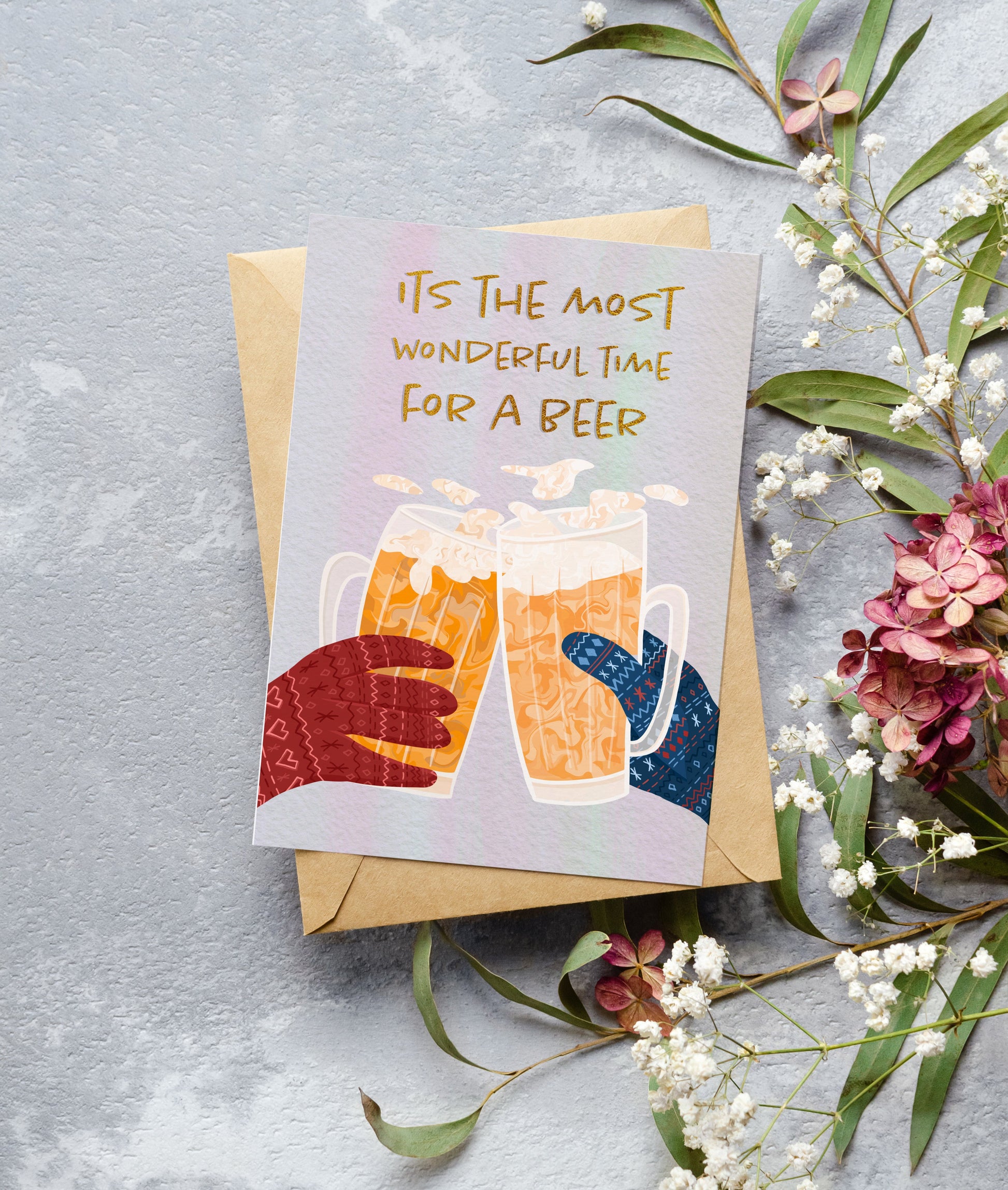 Greeting card with beer illustration and text 'It's the most wonderful time for a beer' on a gray background with flowers.