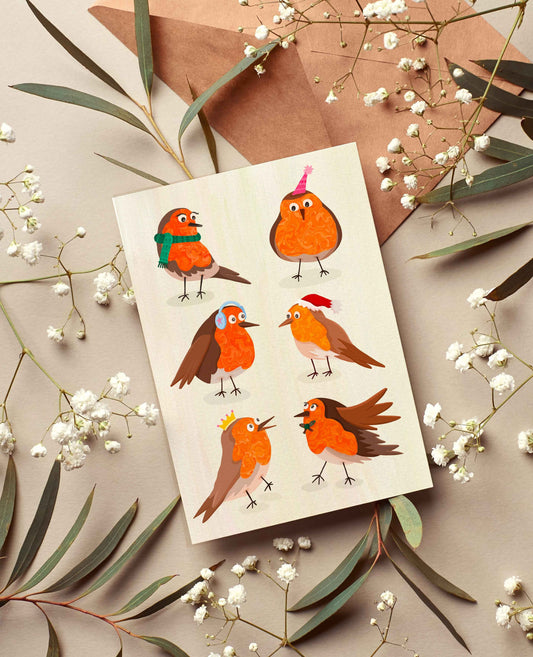Greeting card with illustrated robins on a beige background with leaves and flowers.